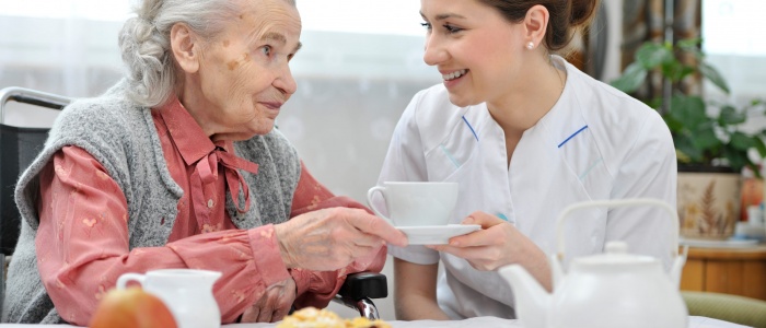 Senior woman eats lunch at retirement home