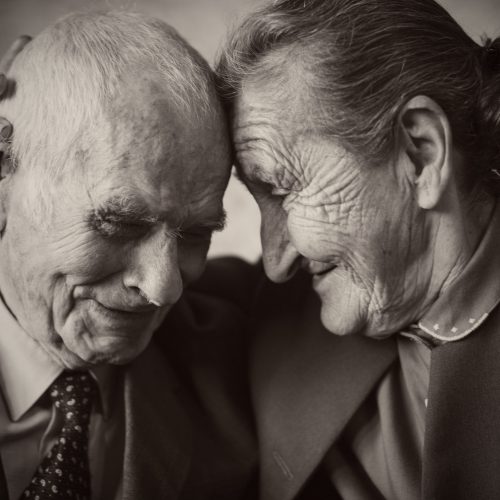 Cute 80 plus year old married couple posing for a portrait in their house. Love forever concept.