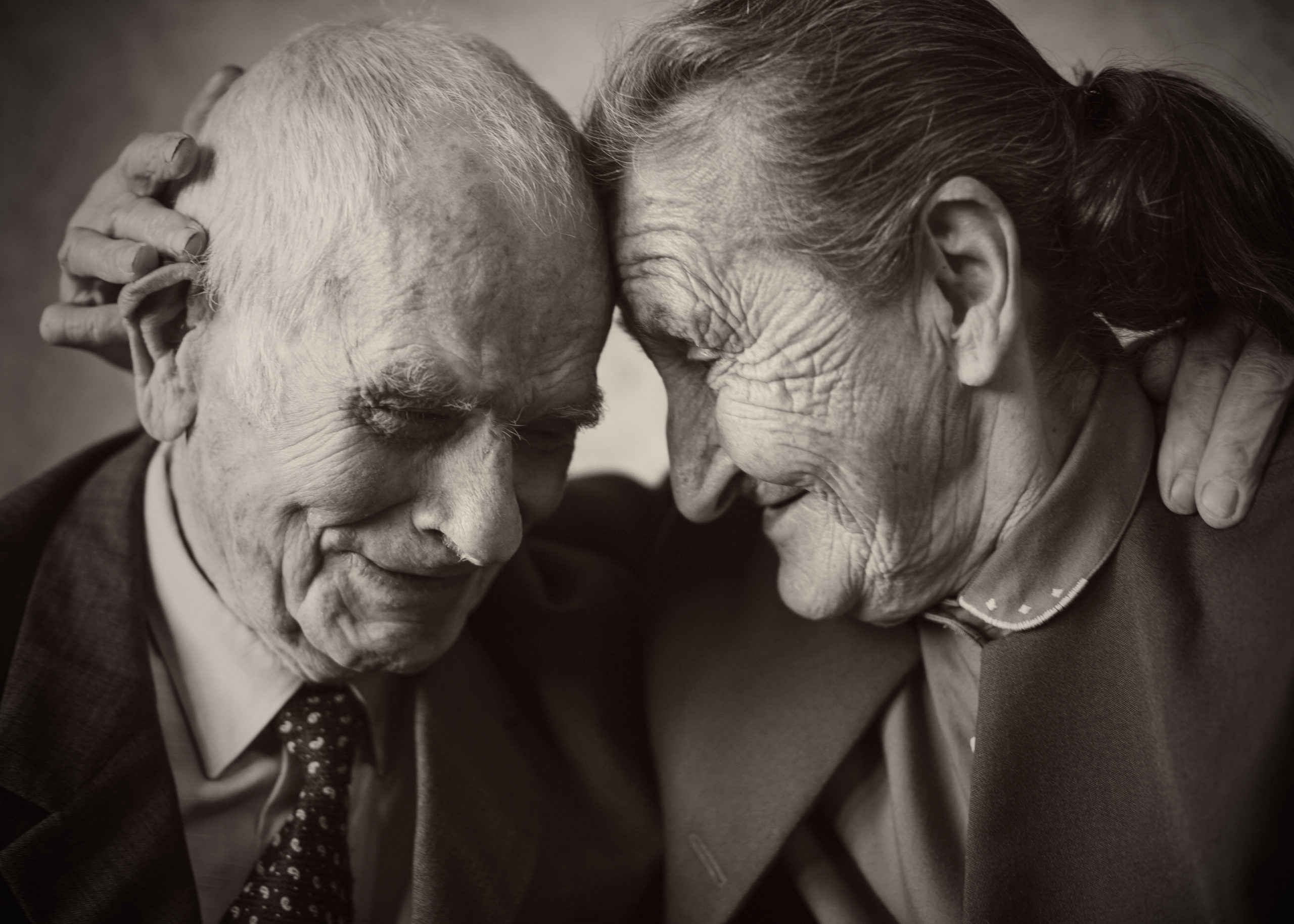 Cute 80 plus year old married couple posing for a portrait in their house. Love forever concept.